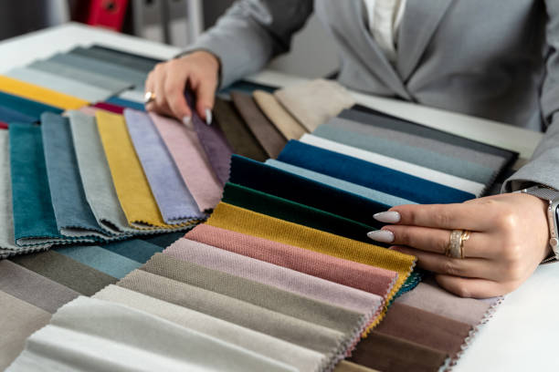 woman designer choose at tissue samples best bright color for a new furniture at home. Fabric sampler