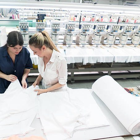Women working at an embroidery factory and supervising the machines as they work